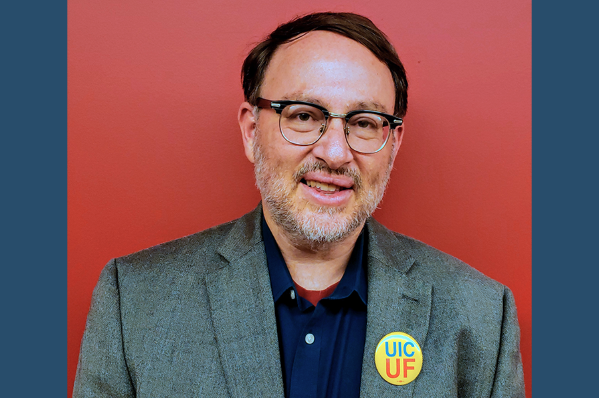 Portrait of man with glasses, gray jacket, against red background